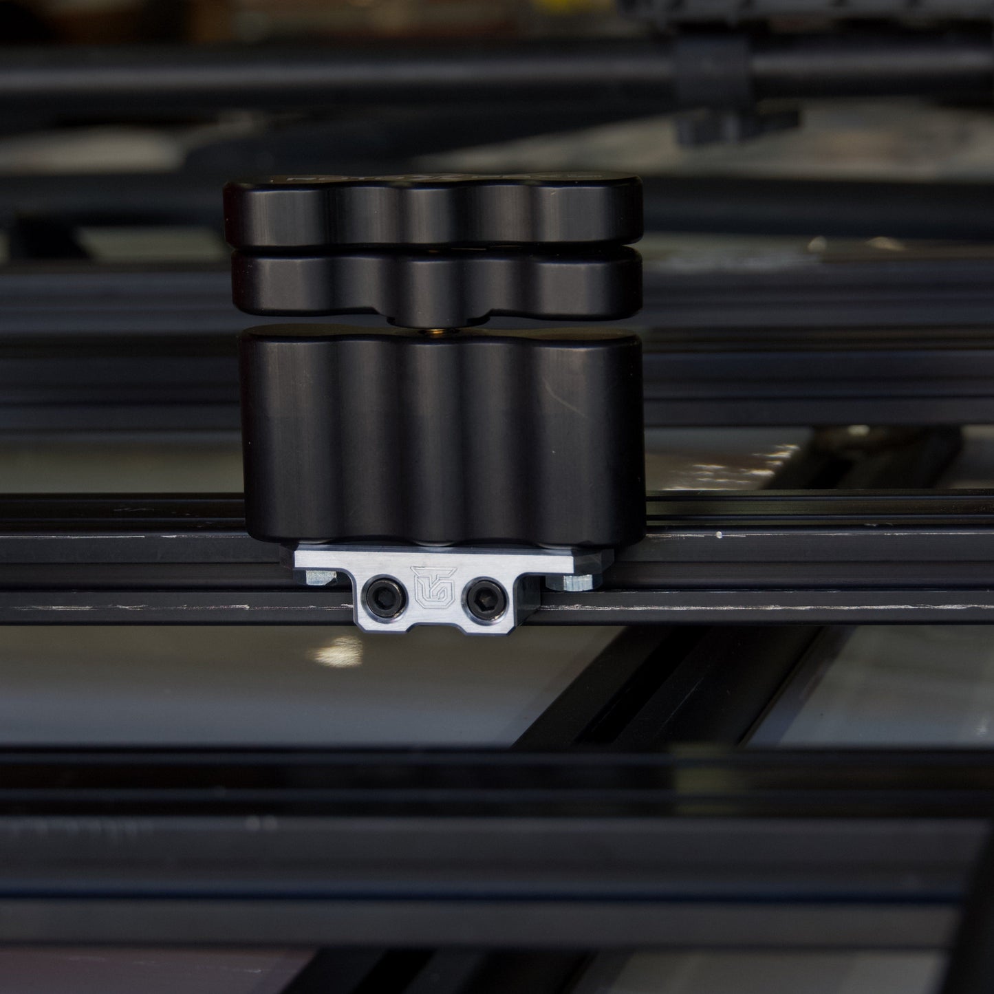 Billet aluminum Rotopax mount adapter for extrusion roof rack cross bars.