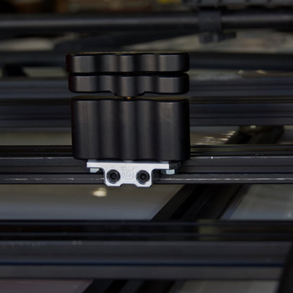 Billet aluminum Rotopax mount adapter for extrusion roof rack cross bars.