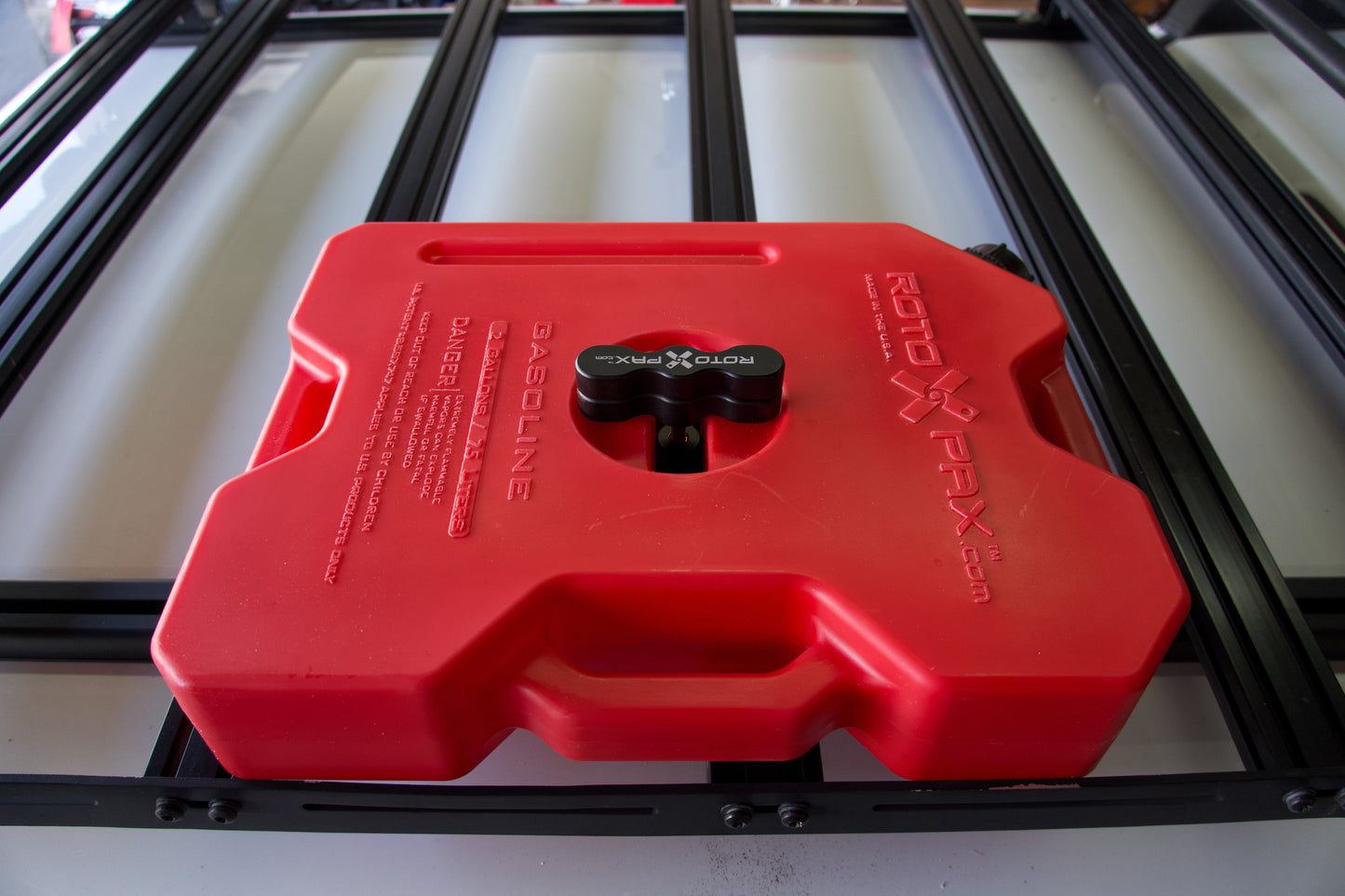 Billet aluminum Rotopax mount adapter for extrusion roof rack cross bars.